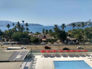 a view of a resort with a swimming pool and the ocean at We Hotel Acapulco in Acapulco