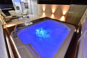 a bath tub with blue water in a room at סוויטת נסיכת המפרץ in Eilat