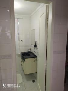 a bathroom with a sink and a mirror at Praia grande canto do forte top in Praia Grande
