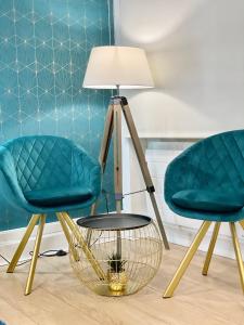 two chairs and a table with a lamp at Appart' Weekly Quartier Impérial Gare in Metz