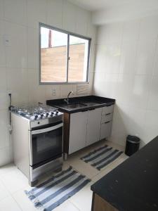 a kitchen with a stove and a sink and a window at Mangaratiba (casa mobiliada) in Mangaratiba