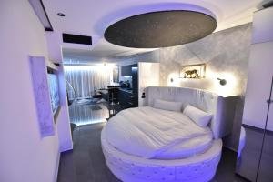 a bedroom with a large white bed with a round stool at סוויטת נסיכת המפרץ in Eilat +39 photos