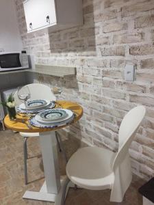 a dining room table with two chairs and a table with wine glasses at Ville France - Chalé Côte d'Azur a 5 min do Centro in Camanducaia +11 photos