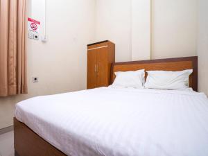 Un dormitorio con una cama grande con sábanas blancas. en Pondok Indah Guest House by ecommerceloka, en Samarinda