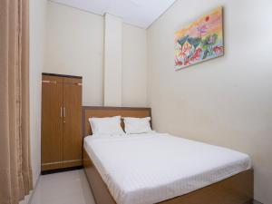- une petite chambre avec un lit et une armoire dans l'établissement Pondok Indah Guest House by ecommerceloka, à Samarinda