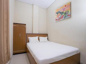1 dormitorio pequeño con 1 cama y armario en Pondok Indah Guest House by ecommerceloka, en Samarinda
