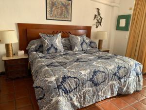 a bedroom with a bed with a blue and white comforter at Vallarta Jr Suites in Puerto Vallarta