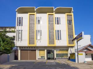 un grand bâtiment blanc aux accents jaunes dans l'établissement Pondok Indah Guest House by ecommerceloka, à Samarinda