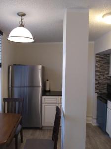 a kitchen with a stainless steel refrigerator and a table at Oceanside Studio in Daytona Beach Shores