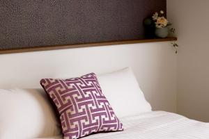 uma almofada sentada em cima de uma cama em Best ever hotel -SEVEN Hotels and Resorts- em Naha