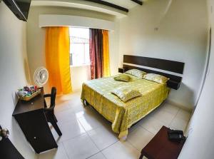 Schlafzimmer mit einem Bett, einem Tisch und einem Fenster in der Unterkunft Hotel Palms Central in Palmira