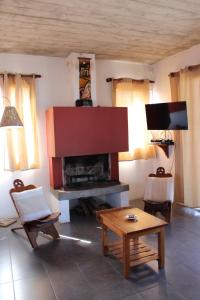 sala de estar con chimenea y TV en Koe Porá, en Punta del Diablo