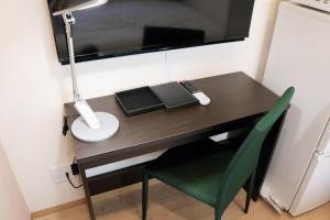 - un bureau avec une chaise, une lampe et un livre dans l'établissement Best ever hotel -SEVEN Hotels and Resorts-, à Naha