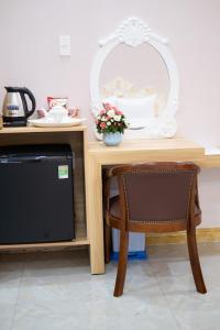 een tafel met een stoel en een spiegel erop bij Quoc Vinh Hotel in Rach Gia