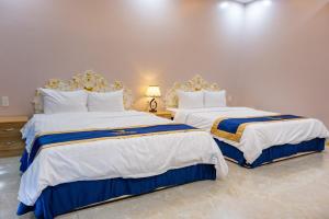 2 Betten in einem weiß-blauen Zimmer in der Unterkunft Quoc Vinh Hotel in Rạch Giá