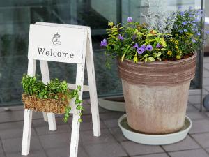 a welcome sign next to a large pot of flowers at Smile Hotel Fukuoka Okawa in Ōkawa