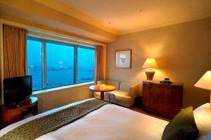 a hotel room with a bed and a large window at Yokohama Royal Park Hotel in Yokohama