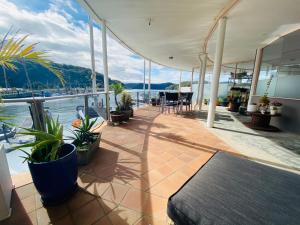 a patio with plants and a view of the water at Jewel of Brooklyn - Hawkesbury River Marina in Brooklyn