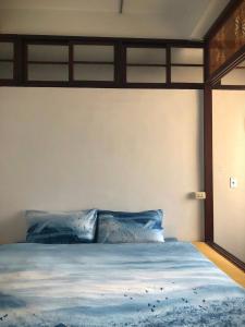 a bedroom with a large bed with blue pillows at FunNan Guesthouse in Tainan