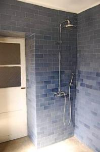 a bathroom with a shower with a blue brick wall at Casa Colonial in Mindelo