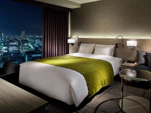 a bedroom with a large bed and a large window at Mitsui Garden Hotel Ginza Premier in Tokyo