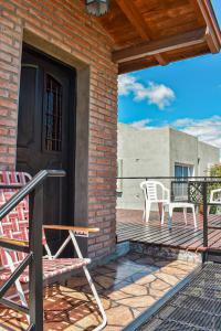 una terraza con 2 sillas y una puerta negra en Monoambiente Amplio, en La Falda