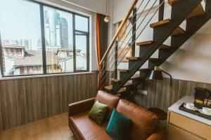 a living room with a staircase and a leather chair at Shanghai Fish Inn People Square in Shanghai