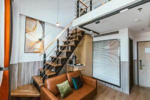 a staircase in a living room with a couch and a stair case at Fishinn Hotel People Square in Shanghai