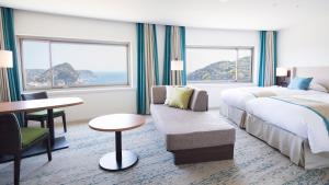 a hotel room with a bed and a couch at Shimoda Tokyu Hotel in Shimoda