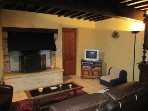 sala de estar con sofá y chimenea en Pretty holiday home with garden near forest, en Isenay