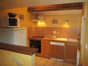 cocina con nevera blanca y fogones horno superior en Pretty holiday home with garden near forest, en Isenay