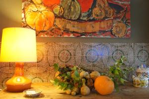 a lamp on a table with pumpkins and a painting at Hotel MR in Tarragona