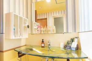a bathroom with a sink and a mirror at Nagasaki Chapel Coconuts Hotel ＆Resort in Isahaya