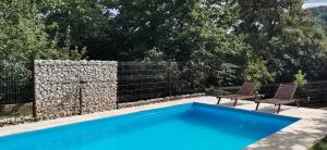 een blauw zwembad met 2 stoelen en een hek bij Calea Poienii Penthouse in Braşov
