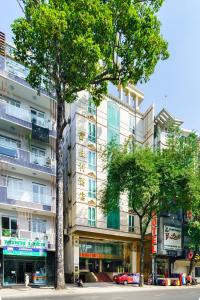 un edificio alto con árboles delante de él en Lam Kinh Hotel en Ho Chi Minh