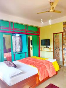 sypialnia z dużym łóżkiem i kolorowymi ścianami w obiekcie Kanchan's Nest w mieście Port Blair