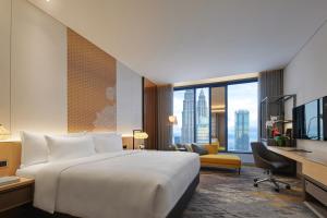 a hotel room with a large bed and a desk at EQ Kuala Lumpur in Kuala Lumpur