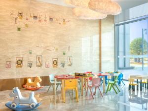 una sala da pranzo con tavoli e sedie colorati di Novotel Changsha International Exhibition Center a Changsha