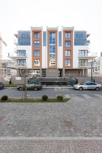 a parking lot with cars parked in front of a building at Apartamenty Pegaz by Renters in Świnoujście