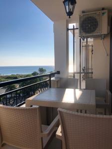 balcón con mesa, sillas y vistas al océano en Borissov Green life apartment Sozopol, en Sozopol