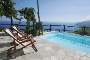 a wooden chair sitting next to a swimming pool at Villa Asterina in Pouríon