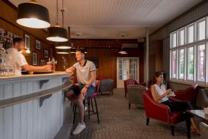 two people sitting at a bar in a restaurant at Golf Hôtel de Valescure & Spa NUXE in Saint-Raphaël +46 photos