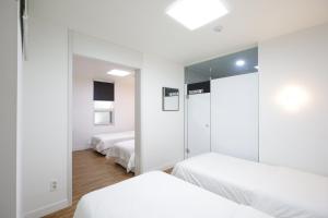 a bedroom with two beds and a mirror at Ekonomy Haeundae Hostel in Busan