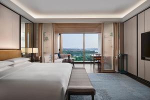 een hotelkamer met een bed en een groot raam bij Park Hyatt Suzhou in Suzhou