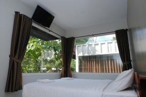 una camera da letto con due letti e una grande finestra di Hau Eco Lodges Citumang Pangandaran a Pangandaran
