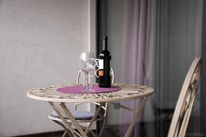 een tafel met een fles wijn en een glas bij Nova galerija Ema in Zagreb