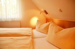 a bedroom with two white beds and a window at Landhaus Braband Ferienhaus - Rugenbargsweg 23 in Cuxhaven