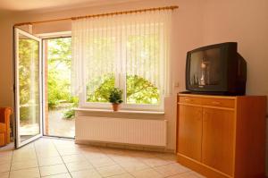 sala de estar con TV y ventana en Landhaus Braband Ferienhaus - Rugenbargsweg 23, en Cuxhaven