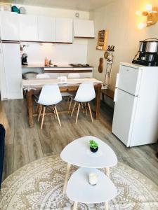 a kitchen with a table and white appliances at Appartement Orcières Merlette Résidence LE DRAC pour 5 personnes in Orcières