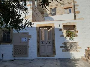a white building with a door and a window at En Patmo Holiday Home in Patmos